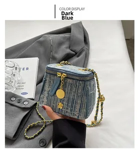 Detail of dark blue tweed mini bag with white weave, golden camellia charm and chain strap