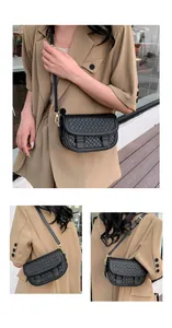 Detail of black woven crossbody bag with gold hardware and adjustable strap on a model