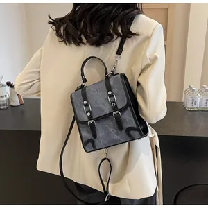 Detail of vintage marble pattern backpack featuring silver buckles and black leather trim