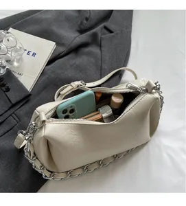 Top view of cream underarm bag showing large interior capacity with phone and cosmetics