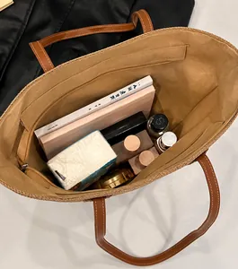 Vista superior del bolso tote de paja con bolsillo interior con cremallera y asas de cuero
