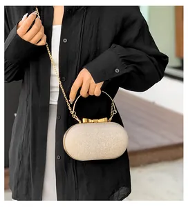 Sparkly evening clutch bag with golden metal bow handle and chain strap for parties