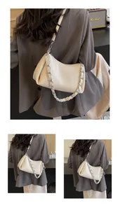 Detail of cream white PU leather bag featuring pleated texture and silver chain strap