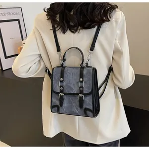 Back view of a vintage British school style backpack with blue marble pattern and black straps
