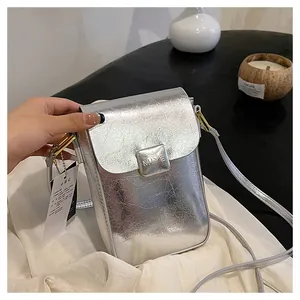 Detail shot of silver metallic mini bag with cracked texture and square metal buckle clasp
