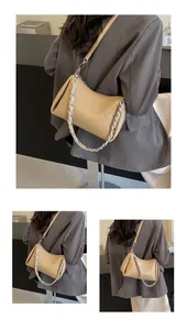 Detail of beige leather shoulder bag with silver chain strap and wrinkled texture