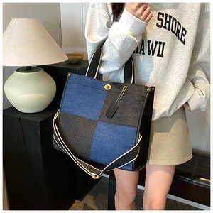 Détail du sac cabas en jean avec coutures color-block et fermoir doré rotatif