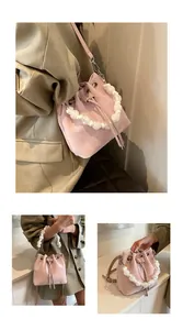 Detail of pink drawstring bucket bag featuring a marble-textured beaded top handle