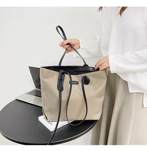 Detail of waterproof nylon tote bag in khaki with black handles and spacious interior