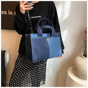 Détail du cabas en denim bicolore avec fermoir doré et bandoulière ornée de perles