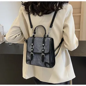 Detail of British vintage backpack showing marble texture and black leather strap on model