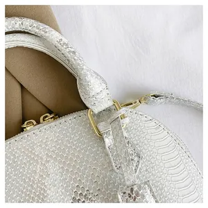 Close-up of snake texture faux leather with premium gold metal hardware and zipper details