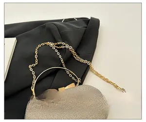 Detailed macro view of the sparkling evening bag with golden chain strap and bow handle