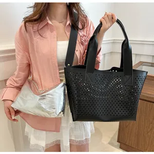 Chic hollowed-out black tote bag and shiny silver sub-bag set shown on a model