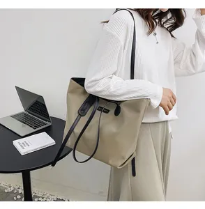 Detail view of khaki waterproof nylon tote bag showing large capacity for laptop use