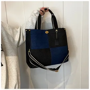 Détail du sac cabas en denim patchwork avec fermoir doré et bandoulière contrastée