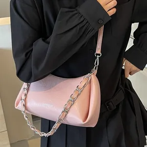 Chic pink pleated underarm bag with silver chain and leather strap on model