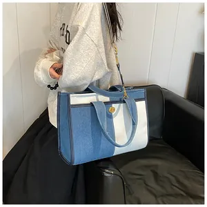 Détail du sac fourre-tout en denim patchwork avec ferrures dorées et bandoulière réglable