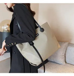 Close-up of khaki waterproof nylon tote bag with black trim and brand logo details