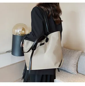 Detail of waterproof nylon tote bag with black straps and minimalist label design