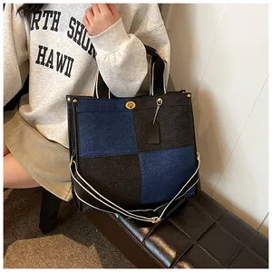 Détail du sac cabas en patchwork de denim avec fermoir tournant doré et étiquette cuir