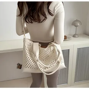 Cream tote bag with decorative hollow-out circular perforations in a modern home setting
