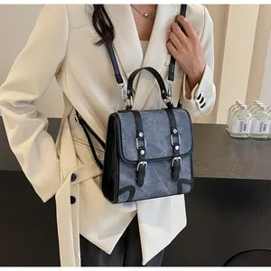 Detail of grey-blue British style backpack with marble texture and black leather buckles
