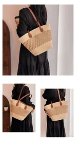 Detail of hand-woven straw tote bag featuring striped patterns and brown leather handles