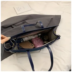 Detail view of the spacious denim tote bag interior with umbrella and daily essentials