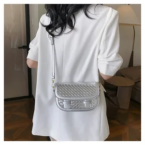 Silver metallic woven saddle bag shown on model with gold hardware and thin strap