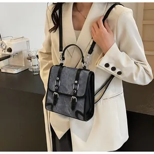 Detail of grey marble pattern backpack with black leather straps and silver metal buckles