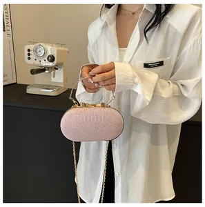 Close-up of pink glitter evening clutch bag with metal bow clasp and ring handle