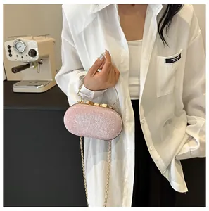 Detail of glitter evening bag with golden bow clasp and metallic handle in light pink