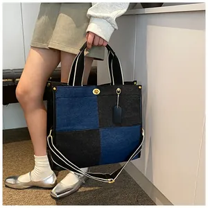 Détails du sac fourre-tout en denim bicolore avec fermoir rotatif et bandoulière