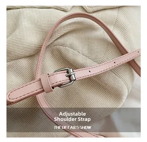 Detail of light pink leather adjustable shoulder strap with silver buckle and stitching