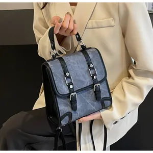Detail of grey marble texture fabric handbag with black leather straps and silver buckles
