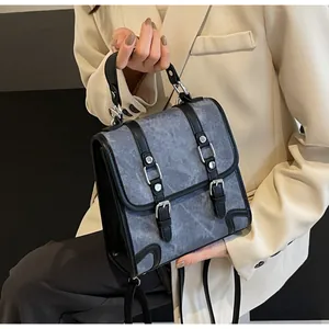 Detail of vintage grey washed canvas handbag with black leather straps and silver buckles