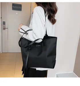 Close-up of black nylon tote bag featuring durable waterproof fabric and logo patch detail