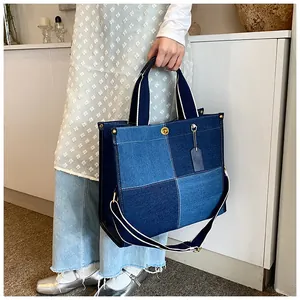 Détail d'un sac cabas en jean patchwork avec design bicolore et bandoulière réglable