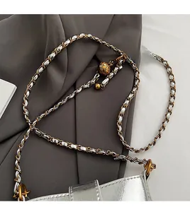 Détail de la bandoulière chaîne argentée avec boucle boule dorée et texture matelassée