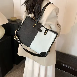 Contrast color canvas tote bag with black faux leather trim and golden hardware