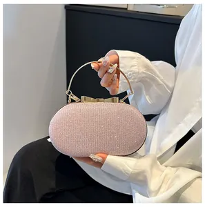 Detail of pink rhinestone evening clutch with gold bow clasp and round metal handle