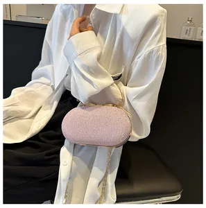Detail of pink rhinestone evening bag with bow metal handle and gold chain strap