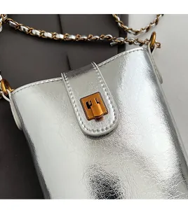 Détail du mini sac argenté brillant avec texture métallique et fermoir bronze vintage