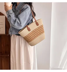 Detail of woven straw tote bag with brown leather strap and wavy texture pattern
