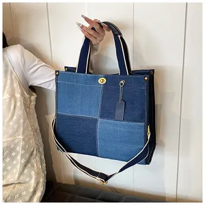 Détail du sac cabas en jean avec design patchwork bleu et fermoir rotatif doré