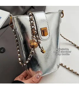 Détail du sac seau argenté métallisé avec chaîne dorée ajustable et breloque boule
