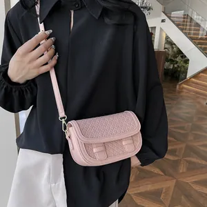 Pink crossbody saddle bag with woven texture and gold metal hooks for women