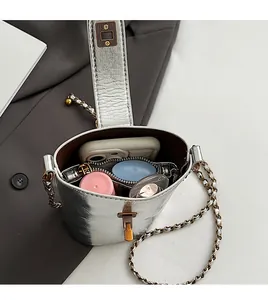 Gros plan sur l'intérieur spacieux de ce sac seau argenté avec des accessoires