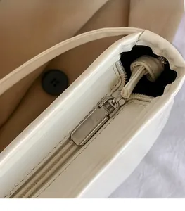 Détail du zip en métal argenté et de la texture du cuir blanc du sac seau chic